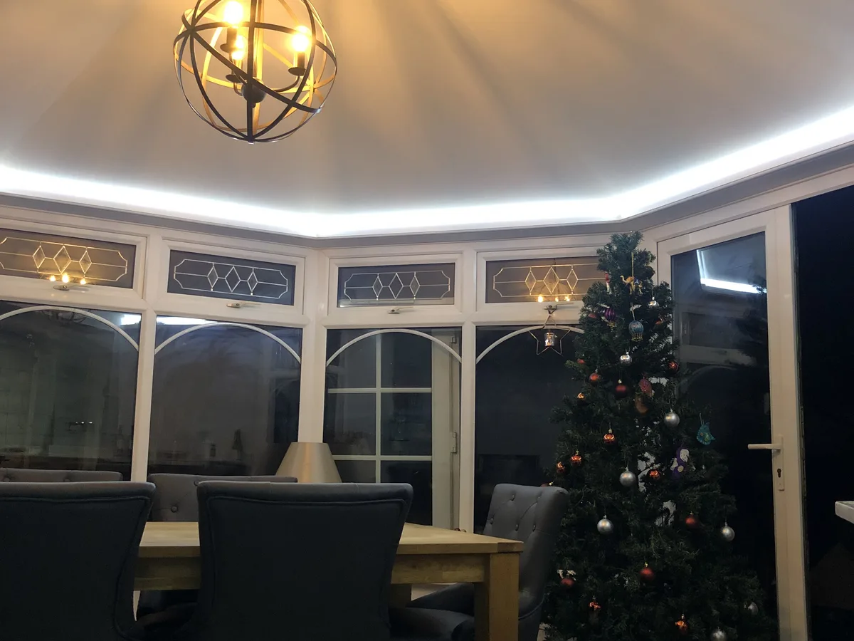 Curved white ceiling with LED strip lighting and globe pendant in a Berkshire dining room