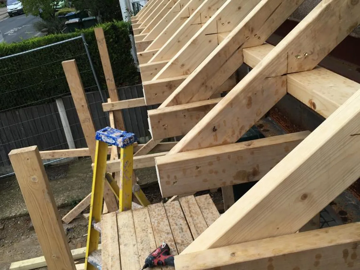 First fix carpentry team laying floor joists on a Ascot, Berkshire new-build project