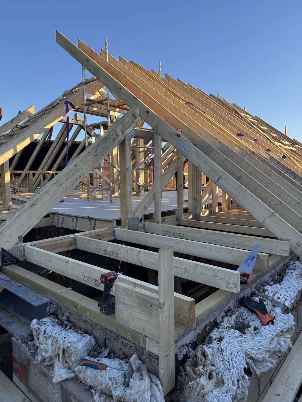 Timber roof frame bathed in golden evening light during first fix construction by Berkshire Bespoke Carpentry