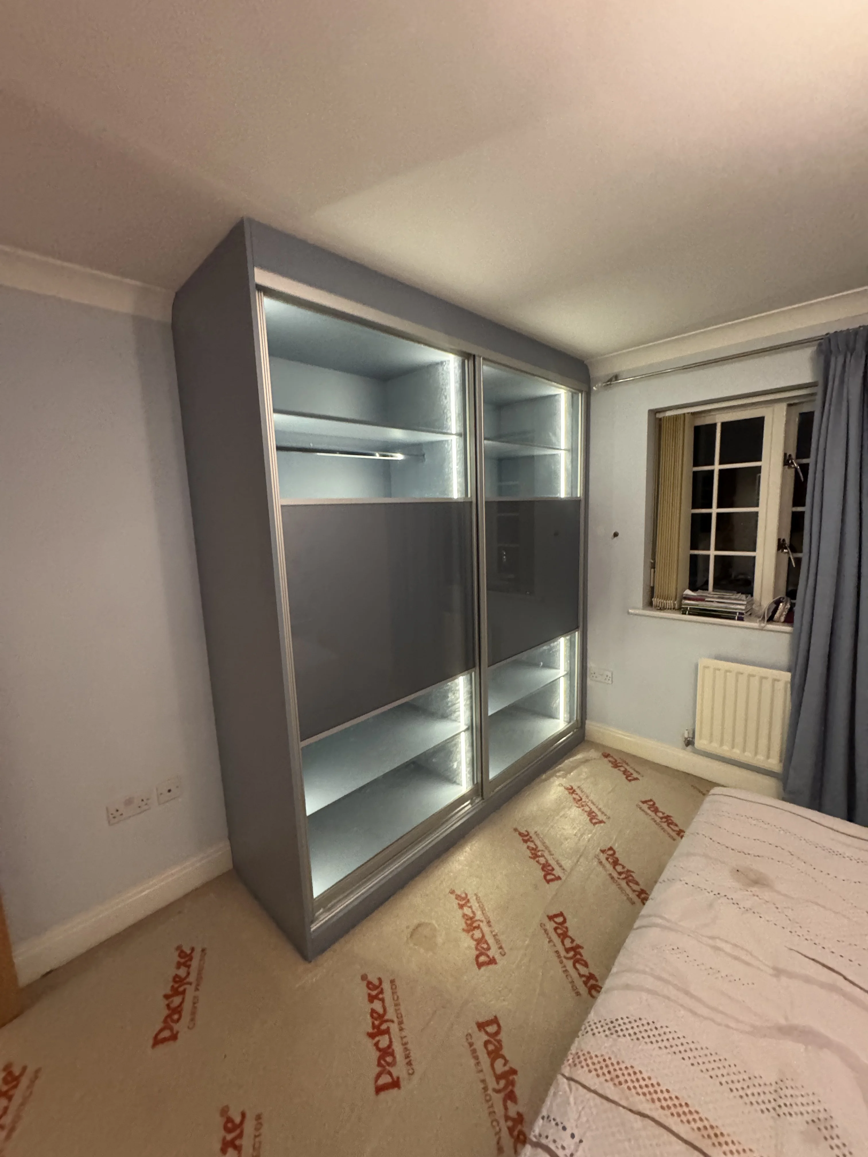 Sliding door fitted wardrobes across a full bedroom wall in Berkshire