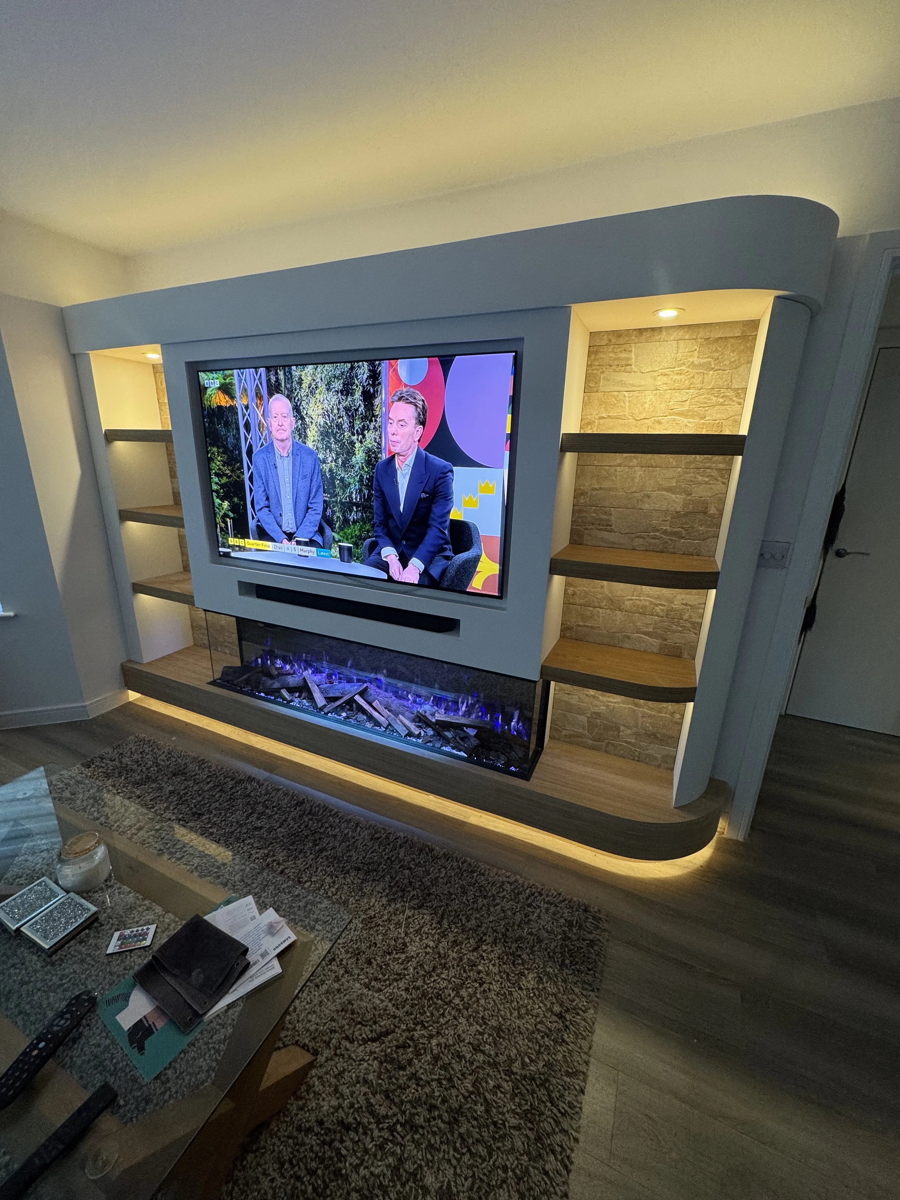 Curved media wall with electric fireplace in a Berkshire living room