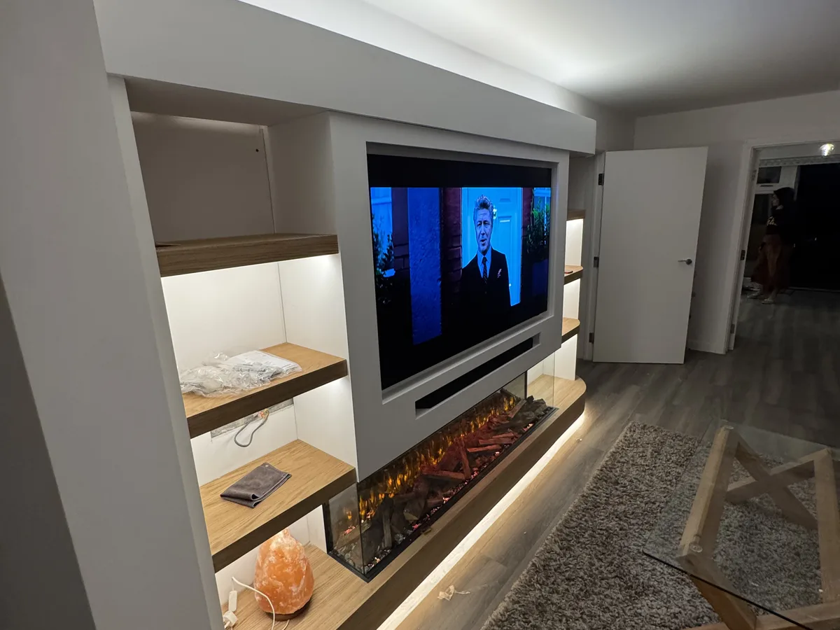 Custom media wall with recessed TV niche and floating shelves in Ascot, Berkshire