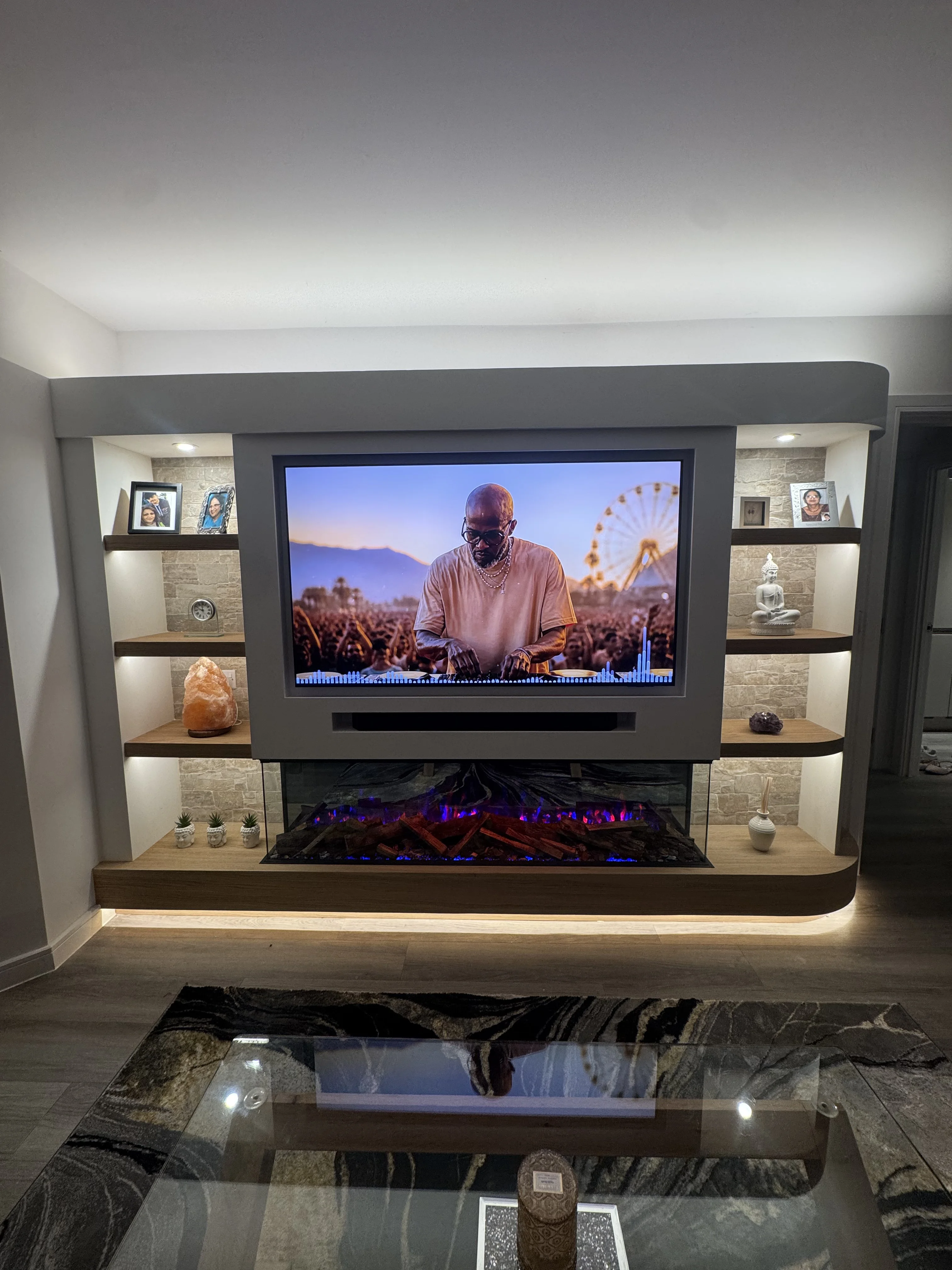 Bespoke media wall with integrated electric fireplace, LED shelving niches, and concealed cables installed in a Berkshire living room