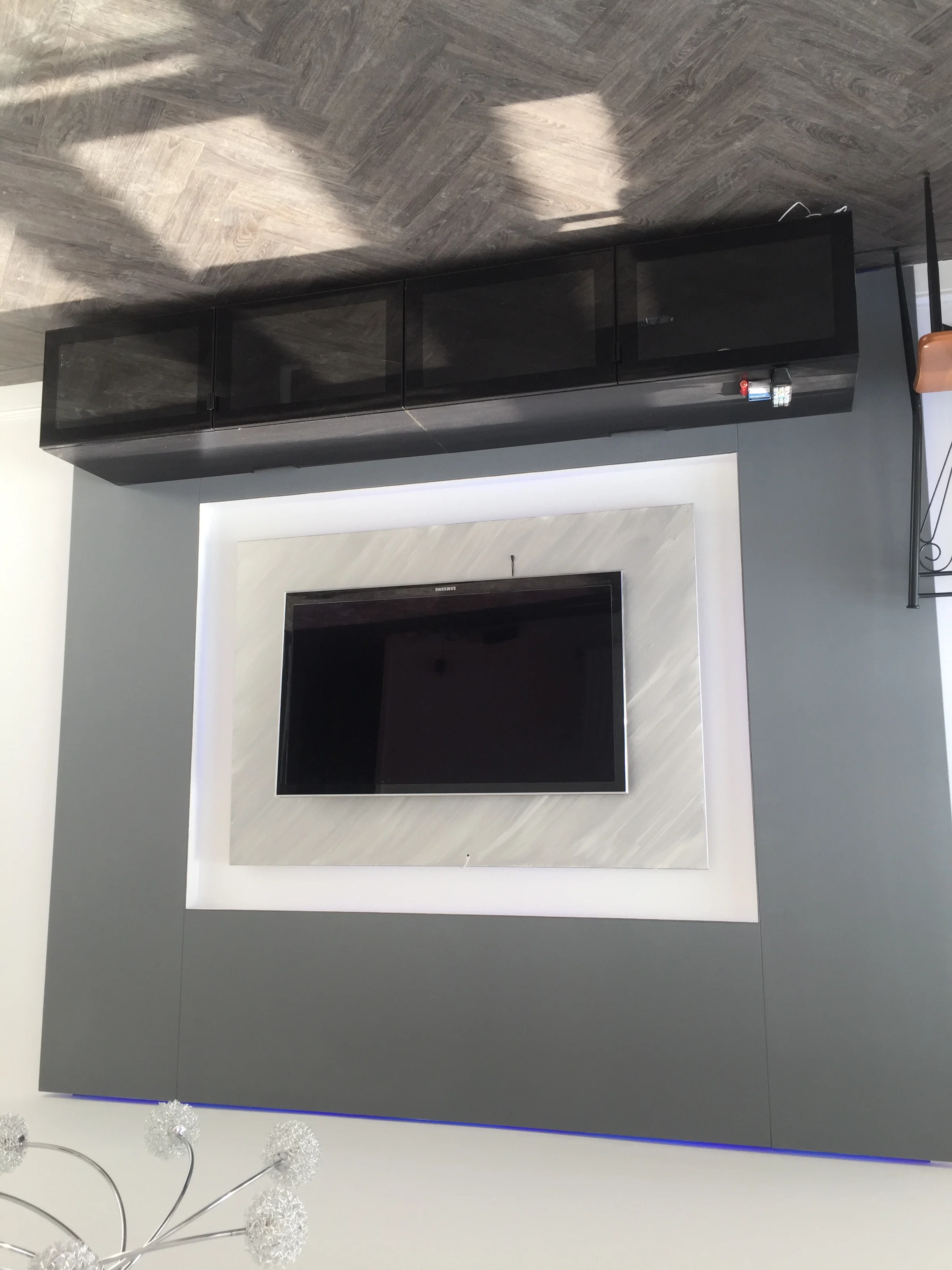 Bespoke media wall with marble alcove and storage in a Berkshire property